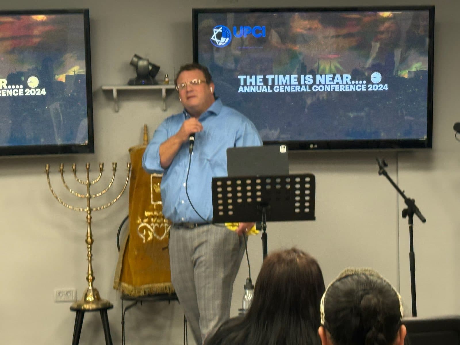 Ministering beside the menorah and Torah scroll